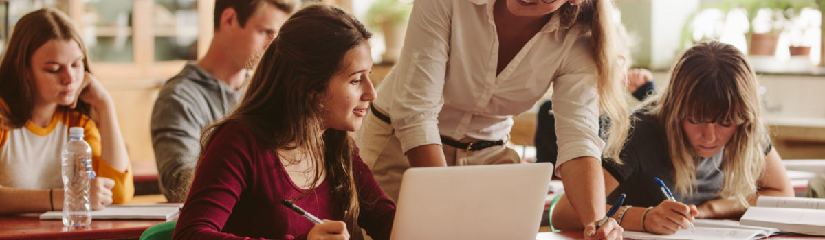 Teacher happy to help student to teacher helping student with behavioural issues in the classroom Teacher happy to help student to teacher helping student with behavioural issues in the classroom