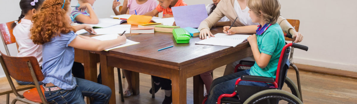 Young teacher sat with children completing equality activities Young teacher sat with children completing equality activities